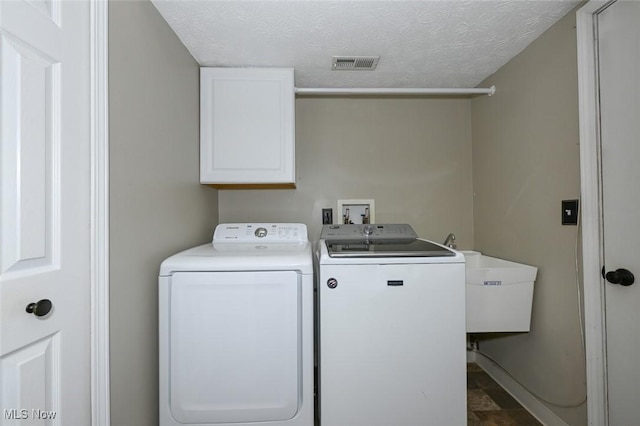 8714 Quailridge Ct, Macedonia, OH 44056 - laundry room featuring cabinet space, separate washer and dryer, and a textured ceiling