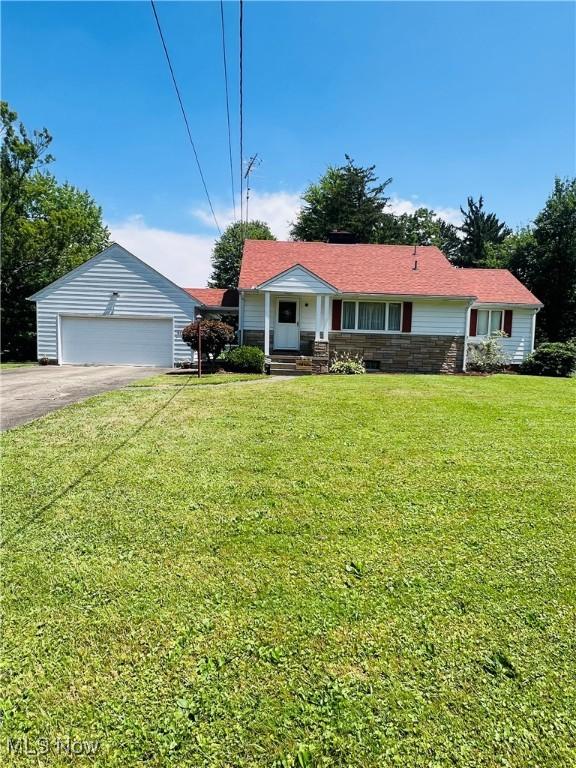 3174 Lynwood Dr NW, Warren, OH 44485 - view of front of home featuring a garage, a front yard, stone siding, and driveway