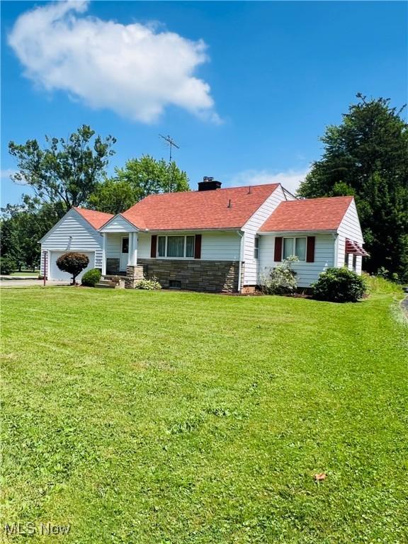 3174 Lynwood Dr NW, Warren, OH 44485 - ranch-style house featuring a chimney, a front lawn, an attached garage, and stone siding