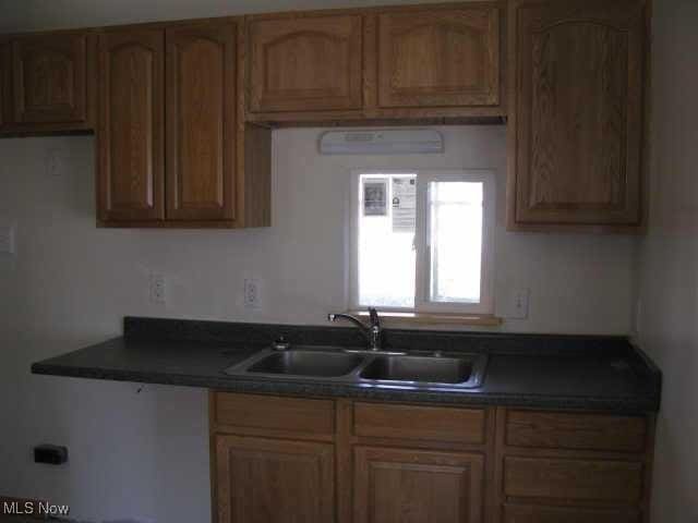 5000 Dimson Dr N, Columbus, OH 43213 - kitchen with dark countertops and brown cabinets