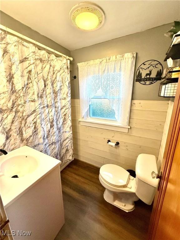 1257 Elmhurst Dr, Weirton, WV 26062 - bathroom featuring vanity, wainscoting, wood finished floors, wood walls, and curtained shower