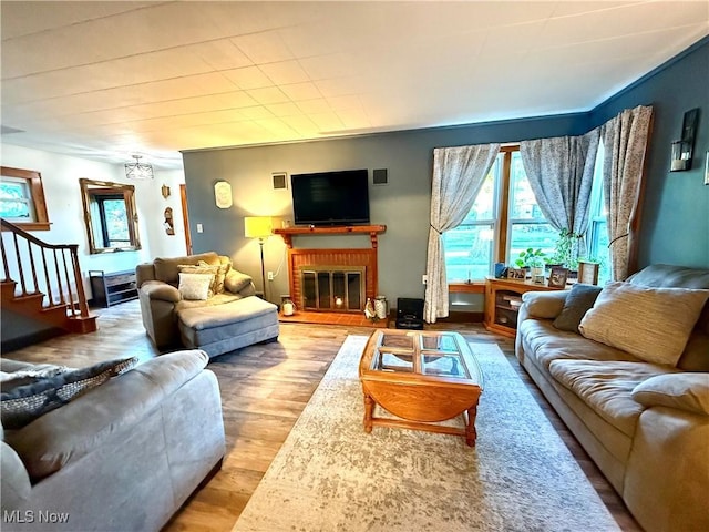 1257 Elmhurst Dr, Weirton, WV 26062 - living area with a brick fireplace, stairway, and wood finished floors