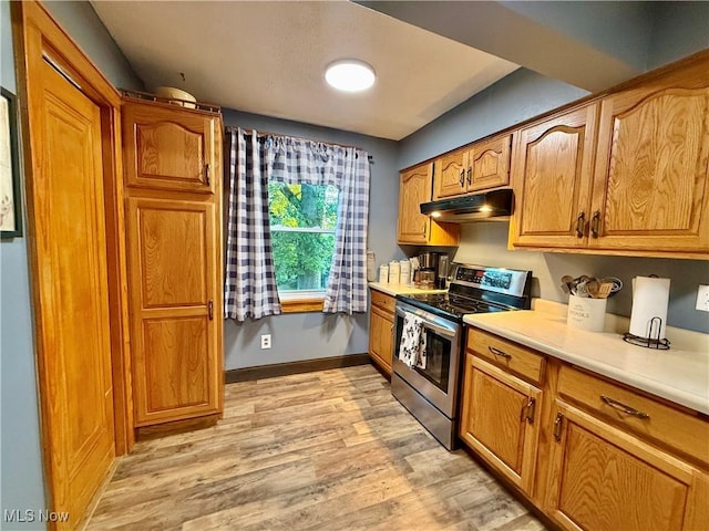 1257 Elmhurst Dr, Weirton, WV 26062 - kitchen featuring electric range, light wood-type flooring, light countertops, under cabinet range hood, and brown cabinets