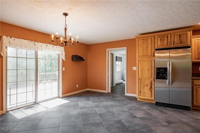 200 Breezy Acres Ln, Walker, WV 26180 - kitchen with stainless steel fridge with ice dispenser, a chandelier, hanging light fixtures, brown cabinets, and dark tile patterned floors