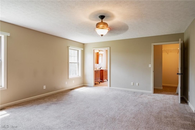 200 Breezy Acres Ln, Walker, WV 26180 - unfurnished bedroom with a walk in closet, a textured ceiling, light colored carpet, connected bathroom, and a ceiling fan