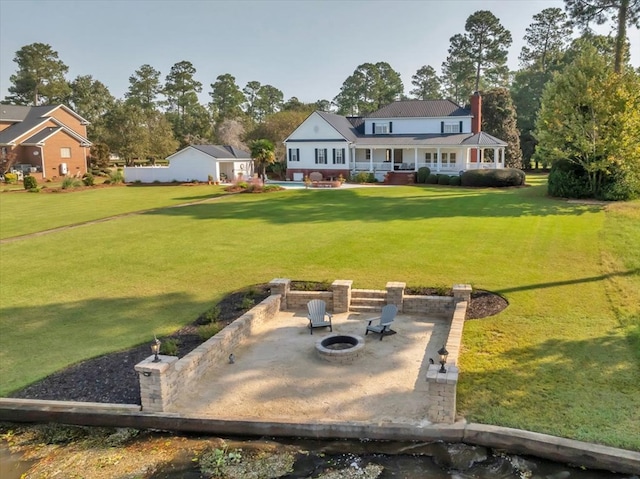 view of yard featuring an outdoor fire pit, an outbuilding, and a patio