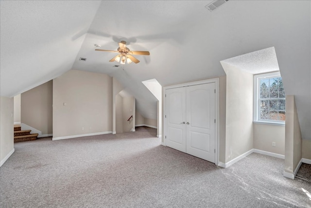 bonus room with ceiling fan, a textured ceiling, carpet floors, and lofted ceiling