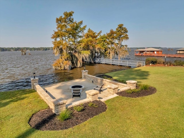 view of yard with a fire pit, a water view, and a patio