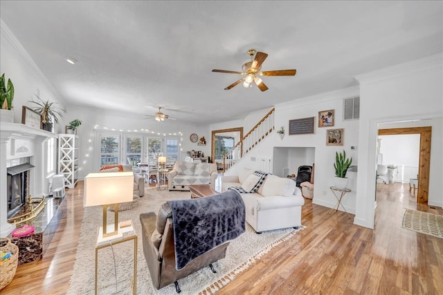 living room with ceiling fan, light hardwood / wood-style flooring, and crown molding