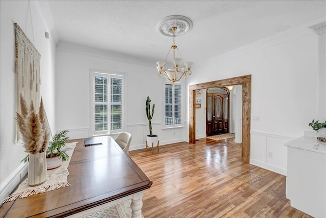 office space featuring hardwood / wood-style floors, crown molding, a notable chandelier, and a textured ceiling