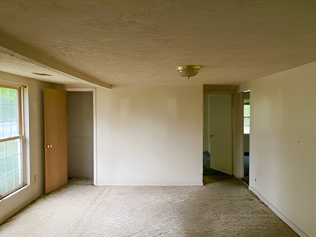 carpeted empty room with a textured ceiling