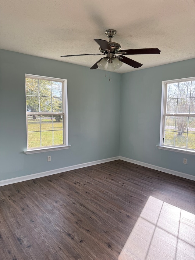 unfurnished room featuring a textured ceiling, ceiling fan, dark wood-style flooring, and baseboards