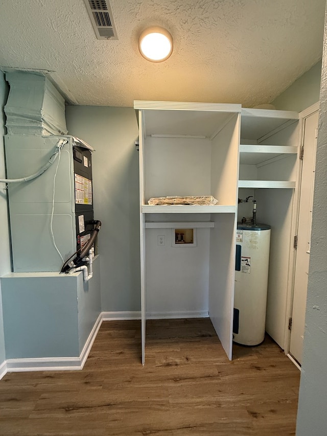 utility room featuring visible vents and electric water heater