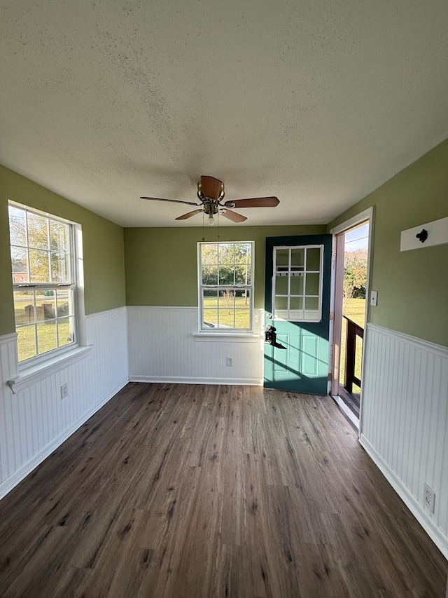 spare room featuring a healthy amount of sunlight and a wainscoted wall