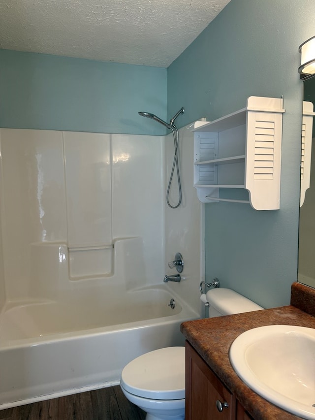 full bath featuring toilet, wood finished floors, tub / shower combination, a textured ceiling, and vanity