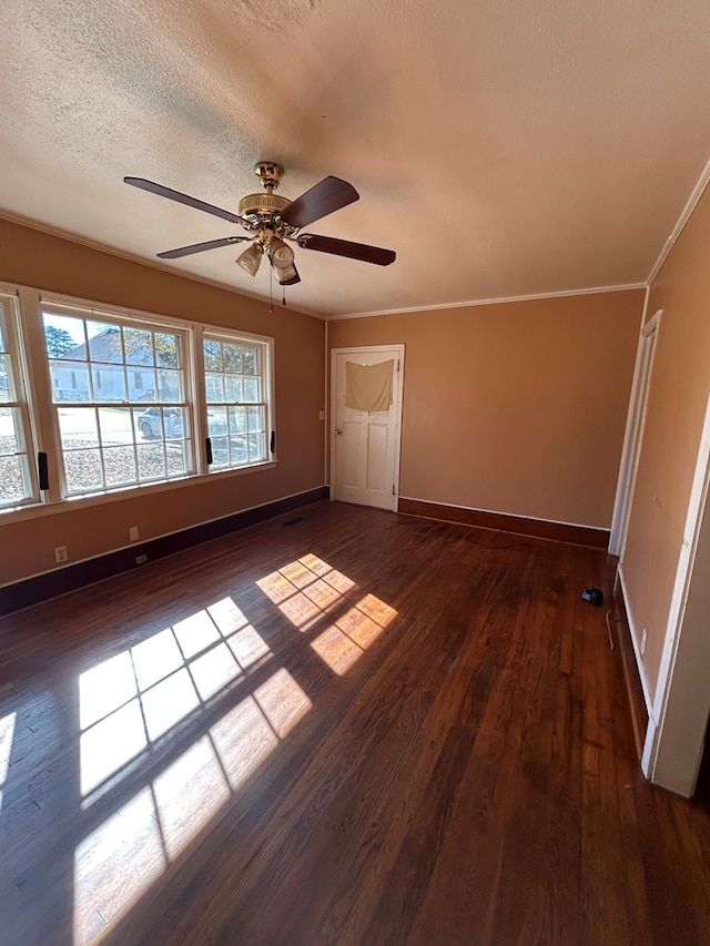 unfurnished room with crown molding, dark wood-type flooring, a textured ceiling, and ceiling fan