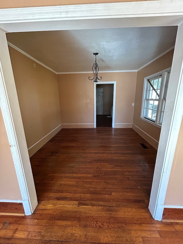 spare room featuring ornamental molding and dark hardwood / wood-style flooring