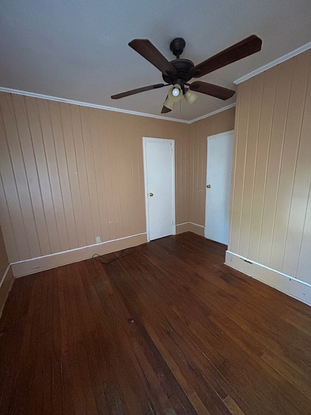 spare room with ornamental molding and dark wood-type flooring