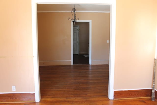 unfurnished dining area featuring crown molding and dark hardwood / wood-style flooring