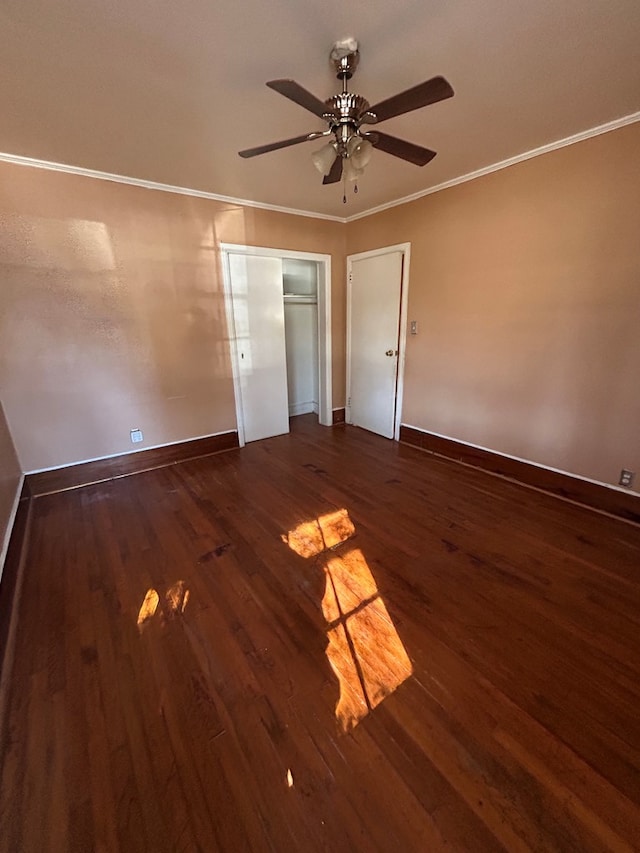 unfurnished bedroom featuring ceiling fan, a closet, crown molding, and dark hardwood / wood-style flooring