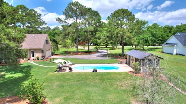 view of swimming pool featuring a patio area, a lawn, and an outdoor structure