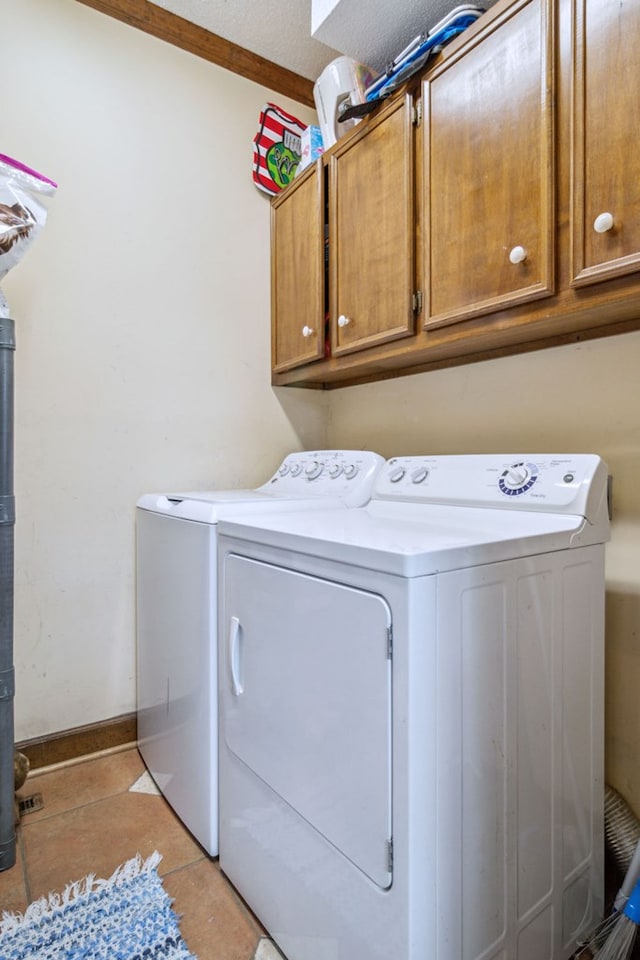 washroom with cabinets, a textured ceiling, independent washer and dryer, and light tile patterned flooring