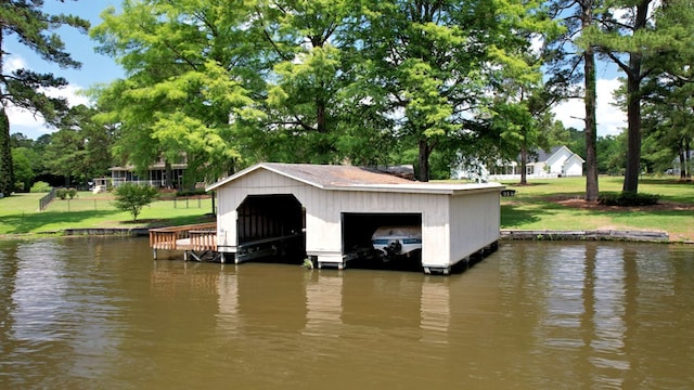 view of dock featuring a lawn and a water view