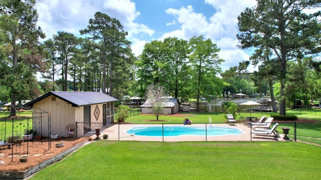 view of pool featuring a patio area, an outbuilding, and a lawn