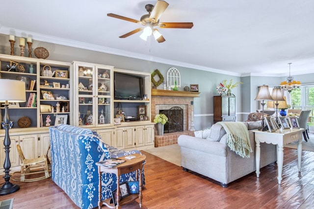 living room with hardwood / wood-style floors, ornamental molding, and a fireplace