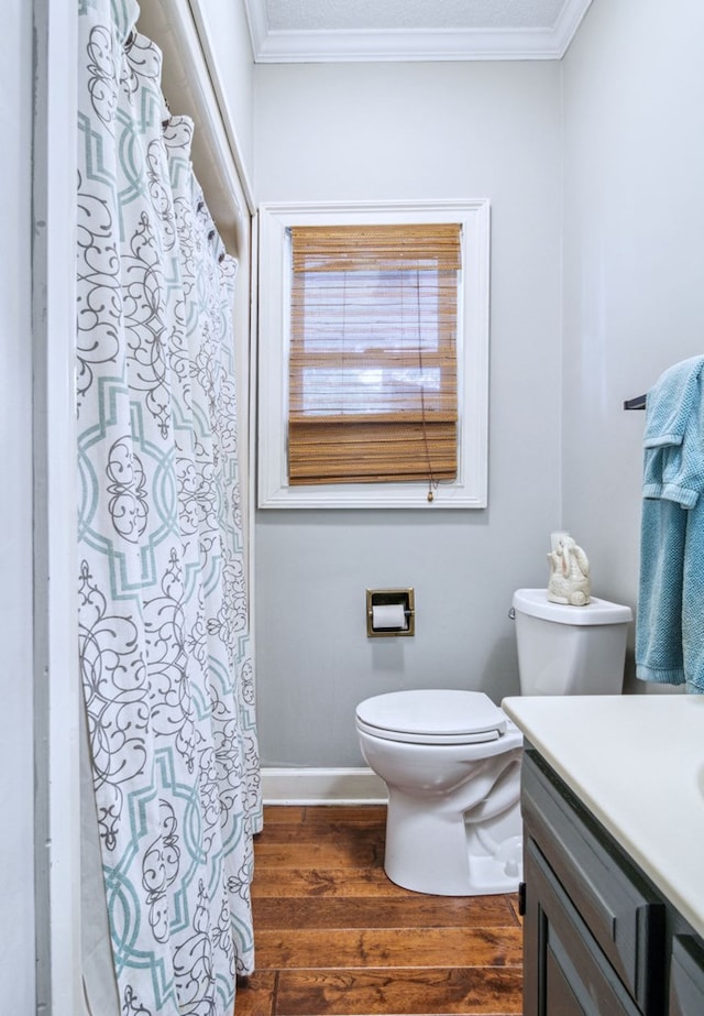 bathroom with vanity, toilet, hardwood / wood-style floors, and ornamental molding