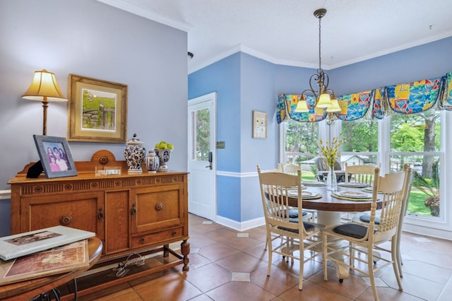 tiled dining area featuring crown molding and a notable chandelier