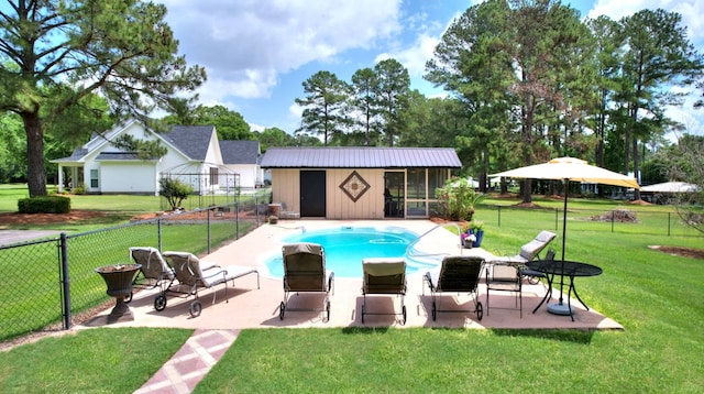 view of pool with a yard, an outbuilding, and a patio