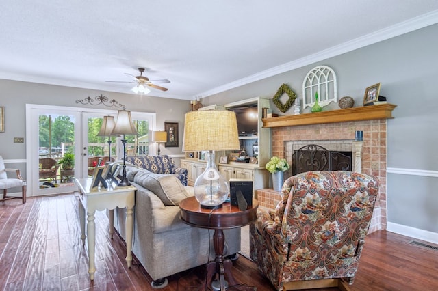 living room with a fireplace, crown molding, dark hardwood / wood-style floors, and french doors