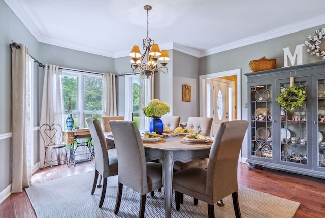 dining room featuring dark hardwood / wood-style flooring, ornamental molding, and an inviting chandelier