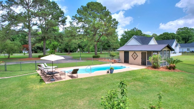 view of swimming pool featuring a patio, an outbuilding, and a yard