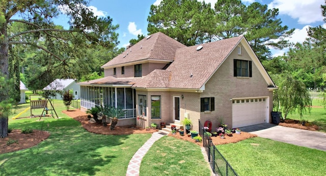 view of front of home featuring a garage, a front lawn, a sunroom, and a playground