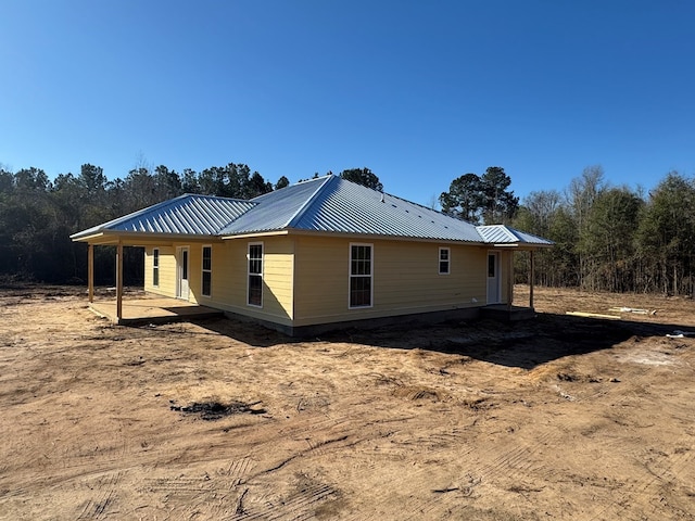 exterior space featuring metal roof and a patio