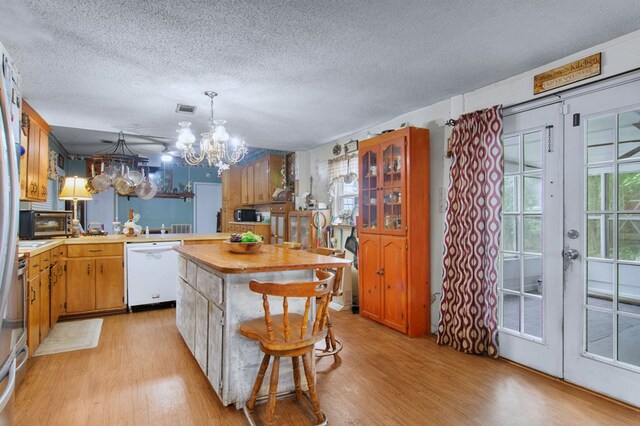 272 Ellis Rd, Plains, GA 31780 - kitchen featuring white dishwasher, a textured ceiling, a notable chandelier, and light wood finished floors