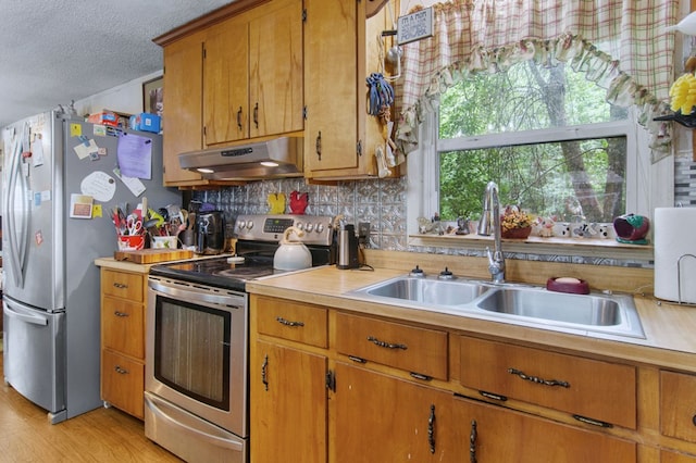 272 Ellis Rd, Plains, GA 31780 - kitchen with light countertops, a textured ceiling, under cabinet range hood, a sink, and appliances with stainless steel finishes