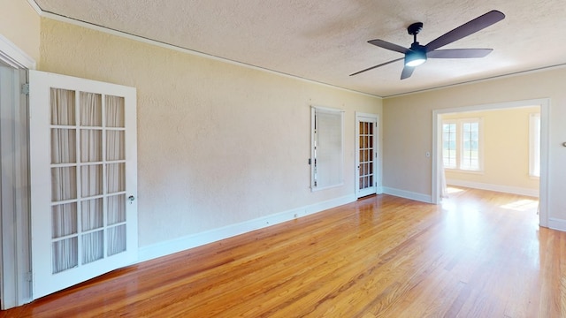 empty room featuring ceiling fan, a textured ceiling, and light wood-type flooring