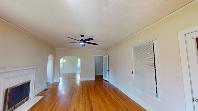 unfurnished living room with light hardwood / wood-style floors, a textured ceiling, ceiling fan, and ornamental molding