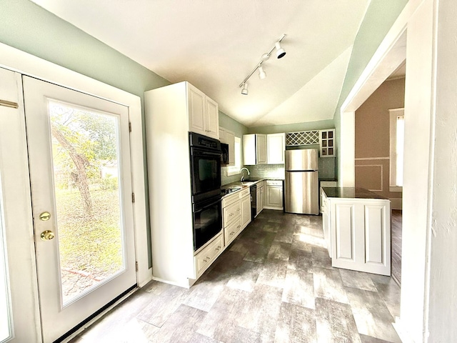 kitchen with sink, white cabinets, a wealth of natural light, black appliances, and lofted ceiling