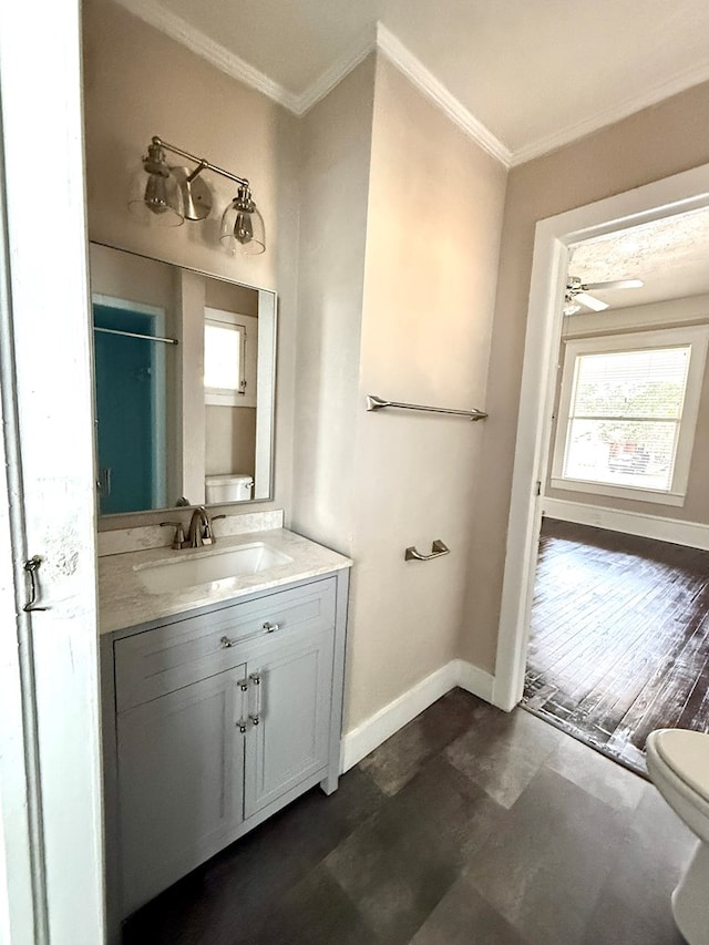 bathroom featuring toilet, walk in shower, ornamental molding, vanity, and ceiling fan