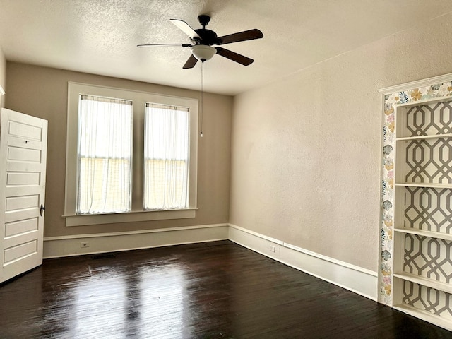 unfurnished room with ceiling fan, a textured ceiling, and dark hardwood / wood-style floors