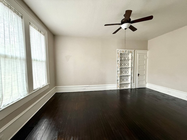 spare room featuring dark hardwood / wood-style floors and ceiling fan