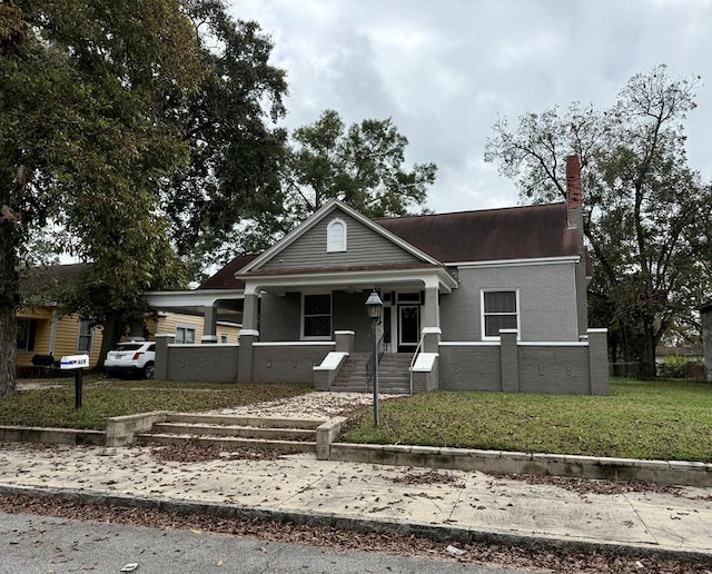 view of front of home with covered porch and a front lawn