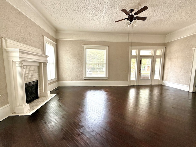 unfurnished living room featuring ceiling fan, dark wood-type flooring, a textured ceiling, and ornamental molding