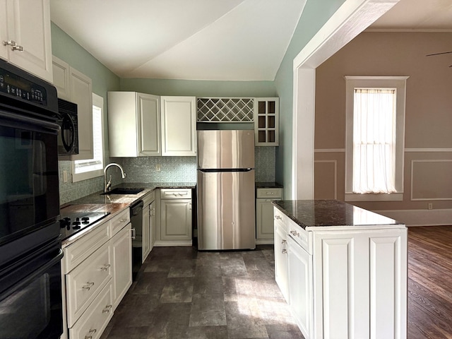 kitchen with sink, black appliances, a center island, and white cabinetry