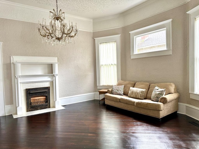 living room featuring dark wood-type flooring, a textured ceiling, an inviting chandelier, and ornamental molding