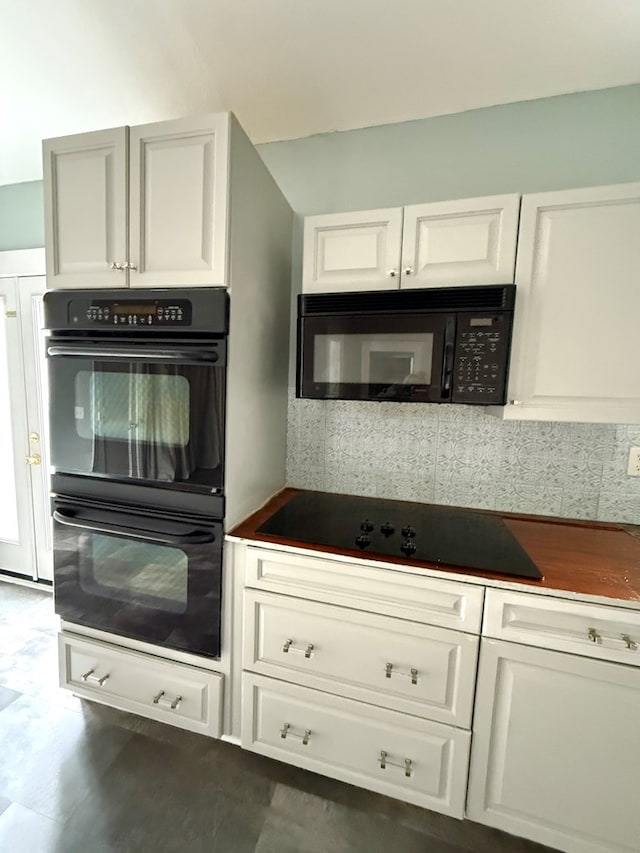 kitchen featuring black appliances, tasteful backsplash, and white cabinetry